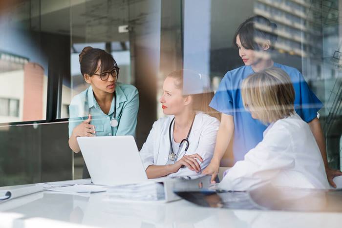 female medical professionals reviewing information on laptop