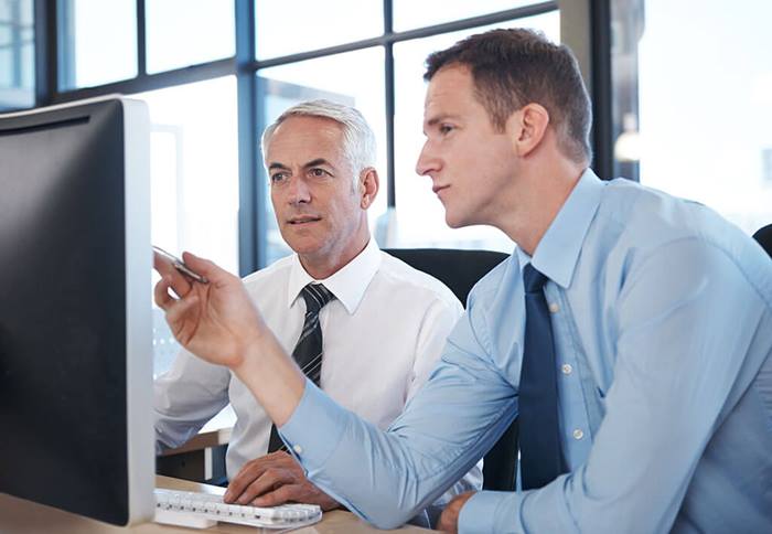 Men reviewing information on computer