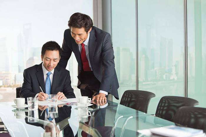 Professional men in meeting signing paperwork